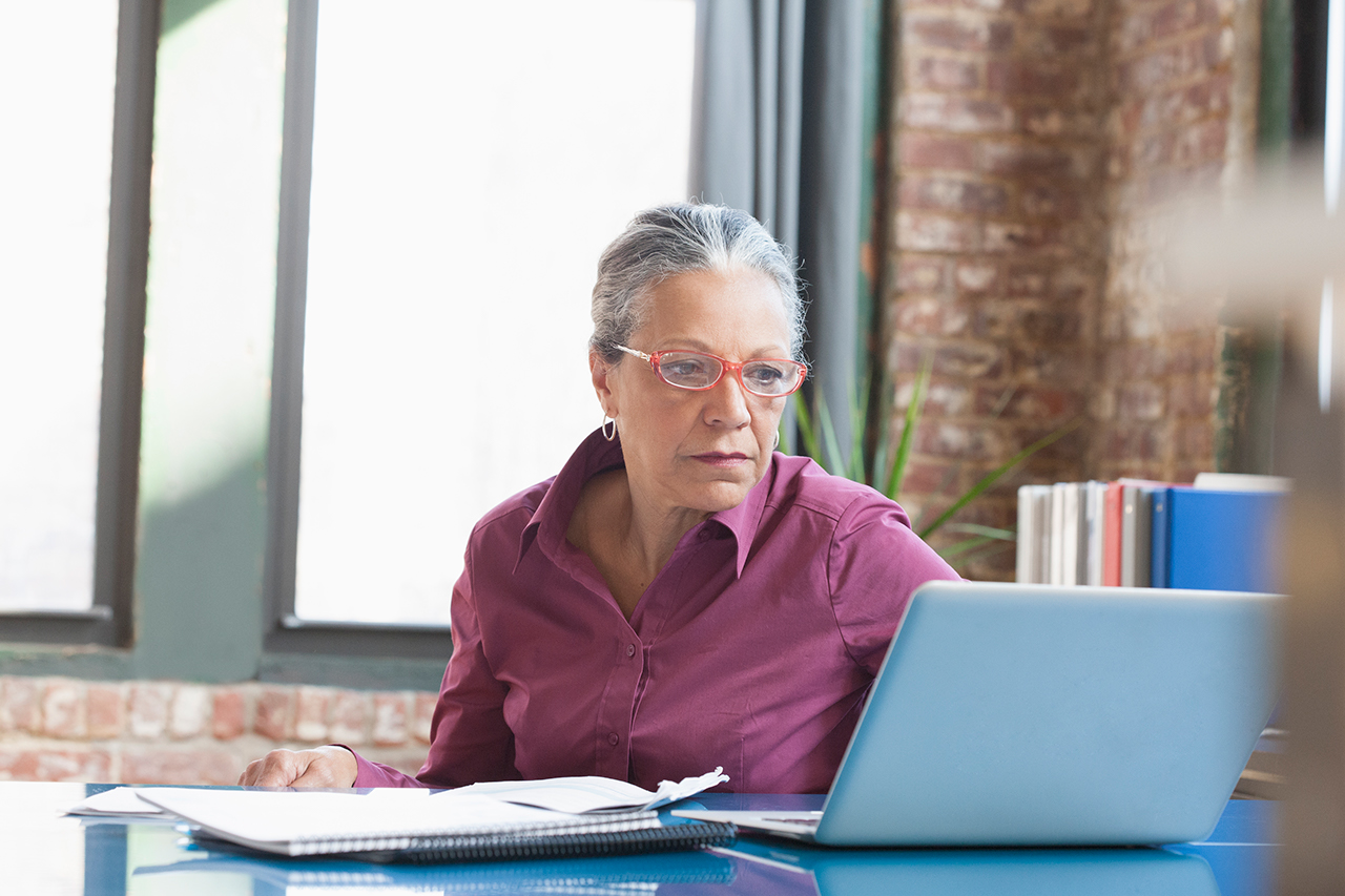 Hispanic businesswoman using laptop in office