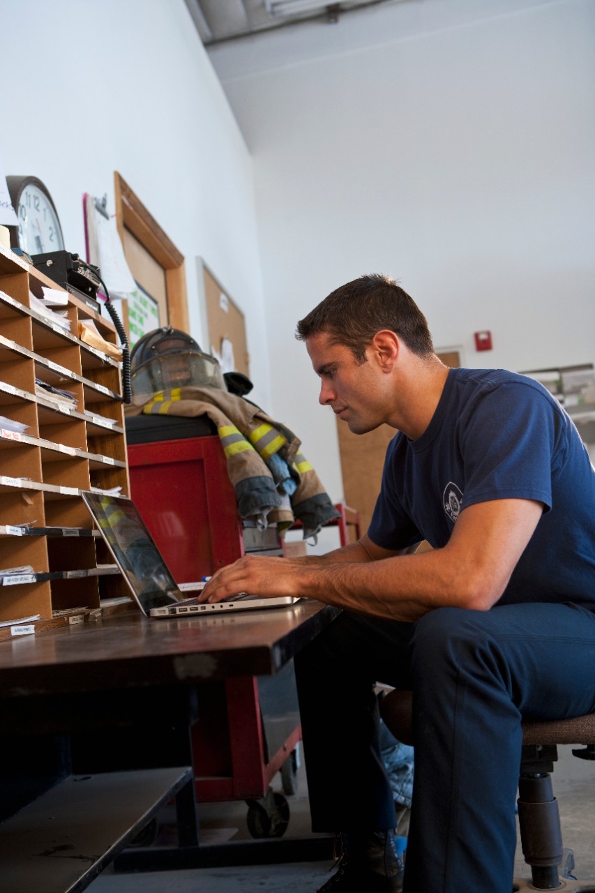 Fireman using laptop at fire station