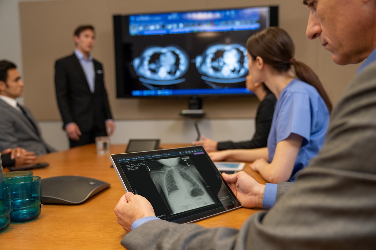 Conference room meeting with x-ray on screen and tablet