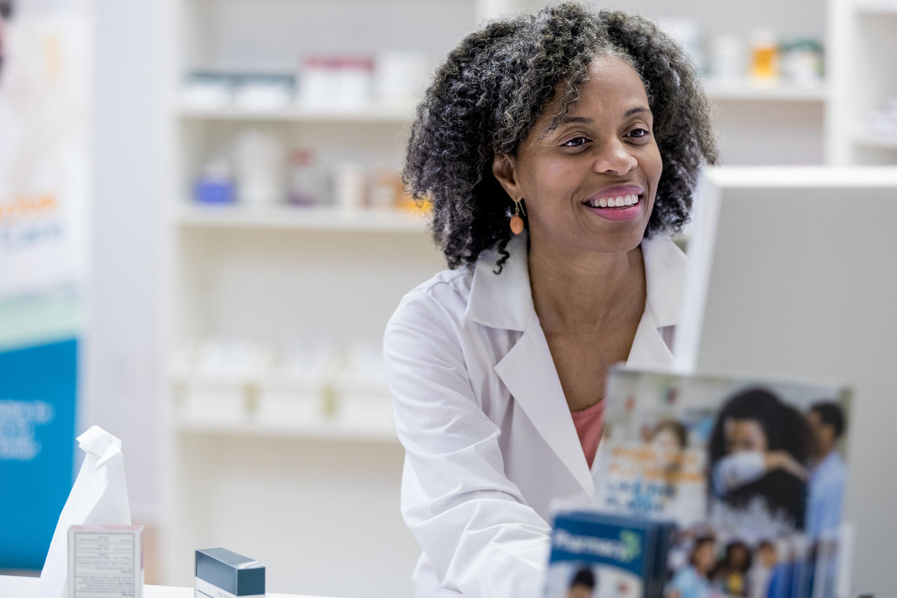Pharmacist smiles while using the computer